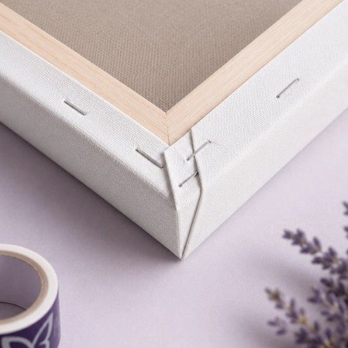 Corner of a canvas stretched over a spruce stretcher bar and stapled at the back